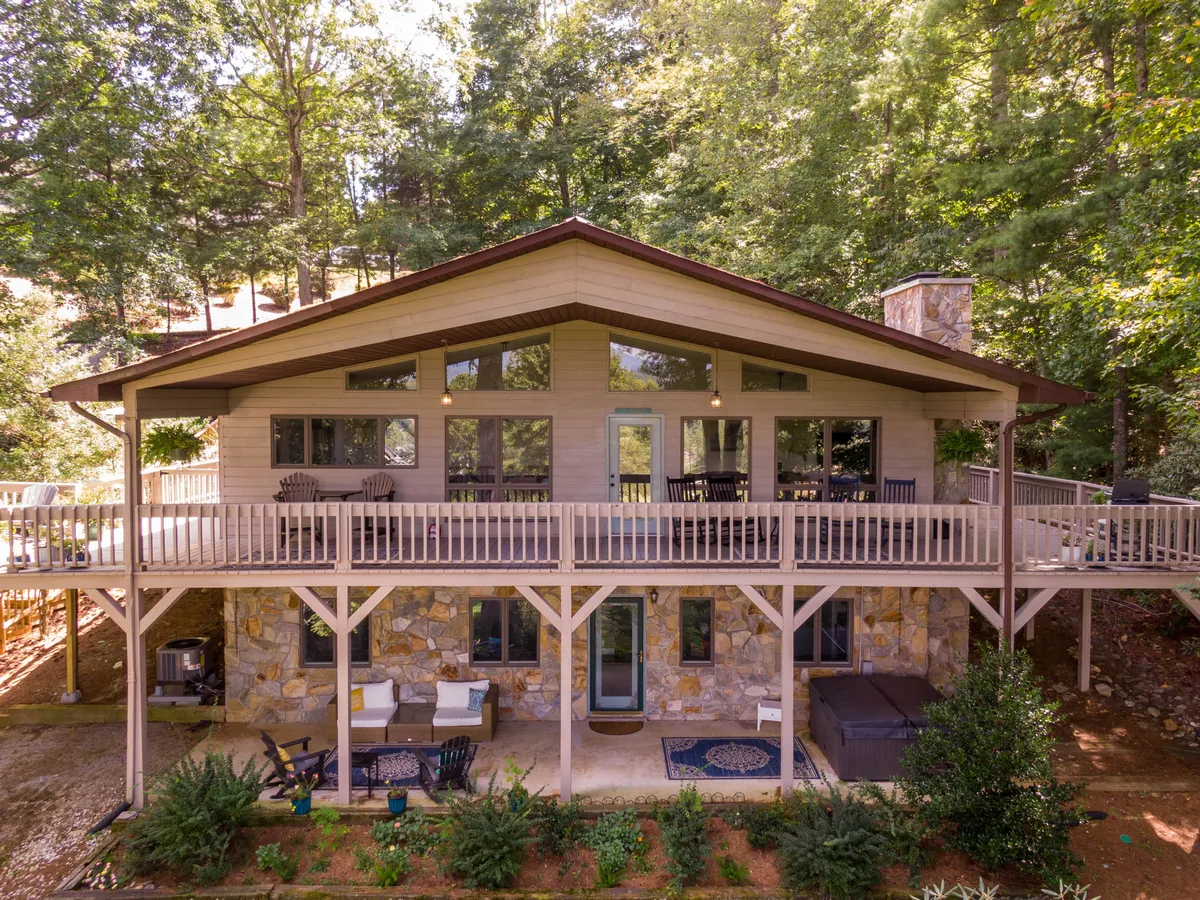 An expansive, gated, and covered outdoor deck with comfortable seating, set against a backdrop of trees. The space invites alfresco gatherings, fresh-air relaxation, and stargazing, all protected by the deck covering.